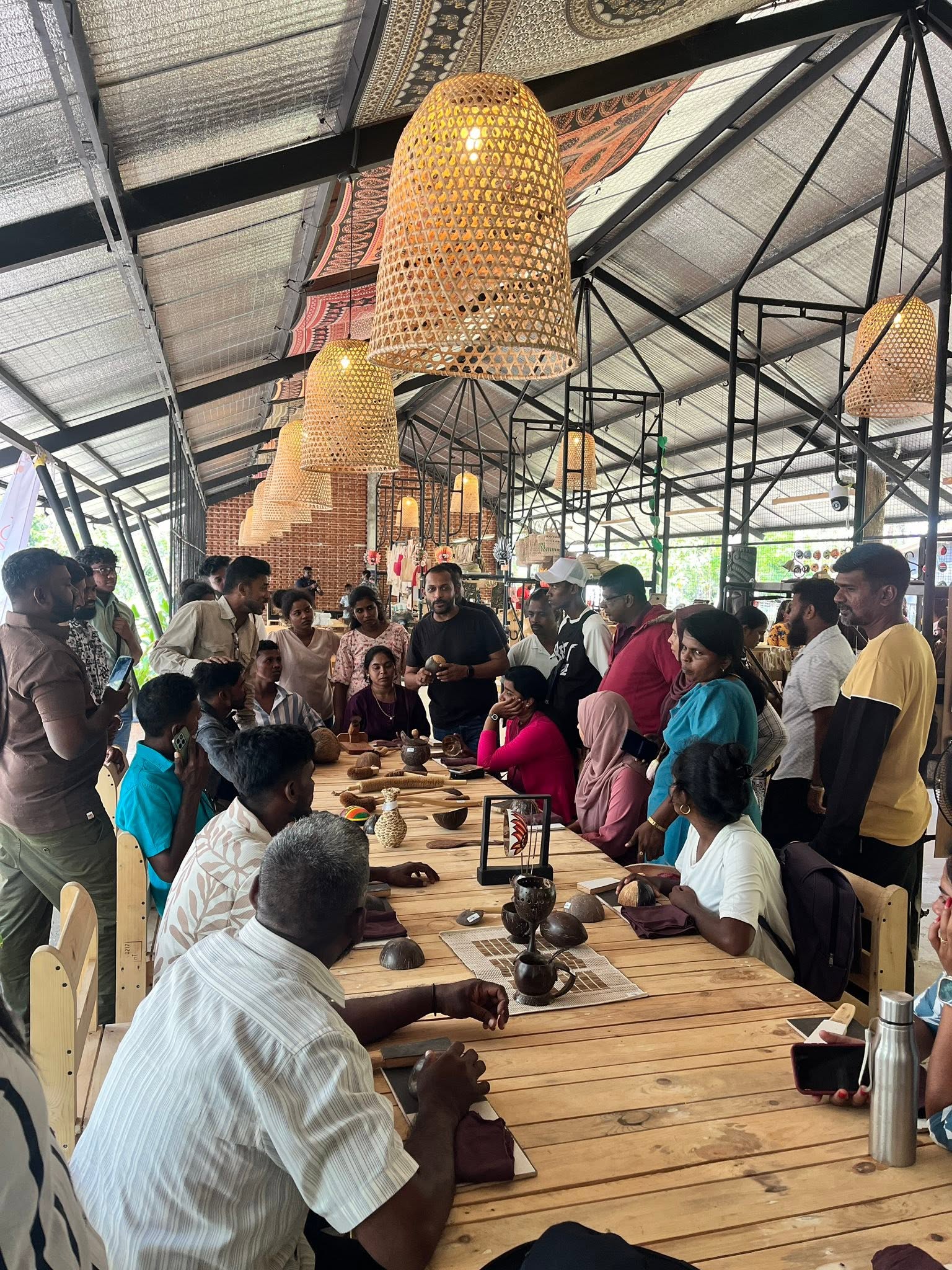 Local artisans and guests gathered around the craft tables at Impact Center Sigiriya