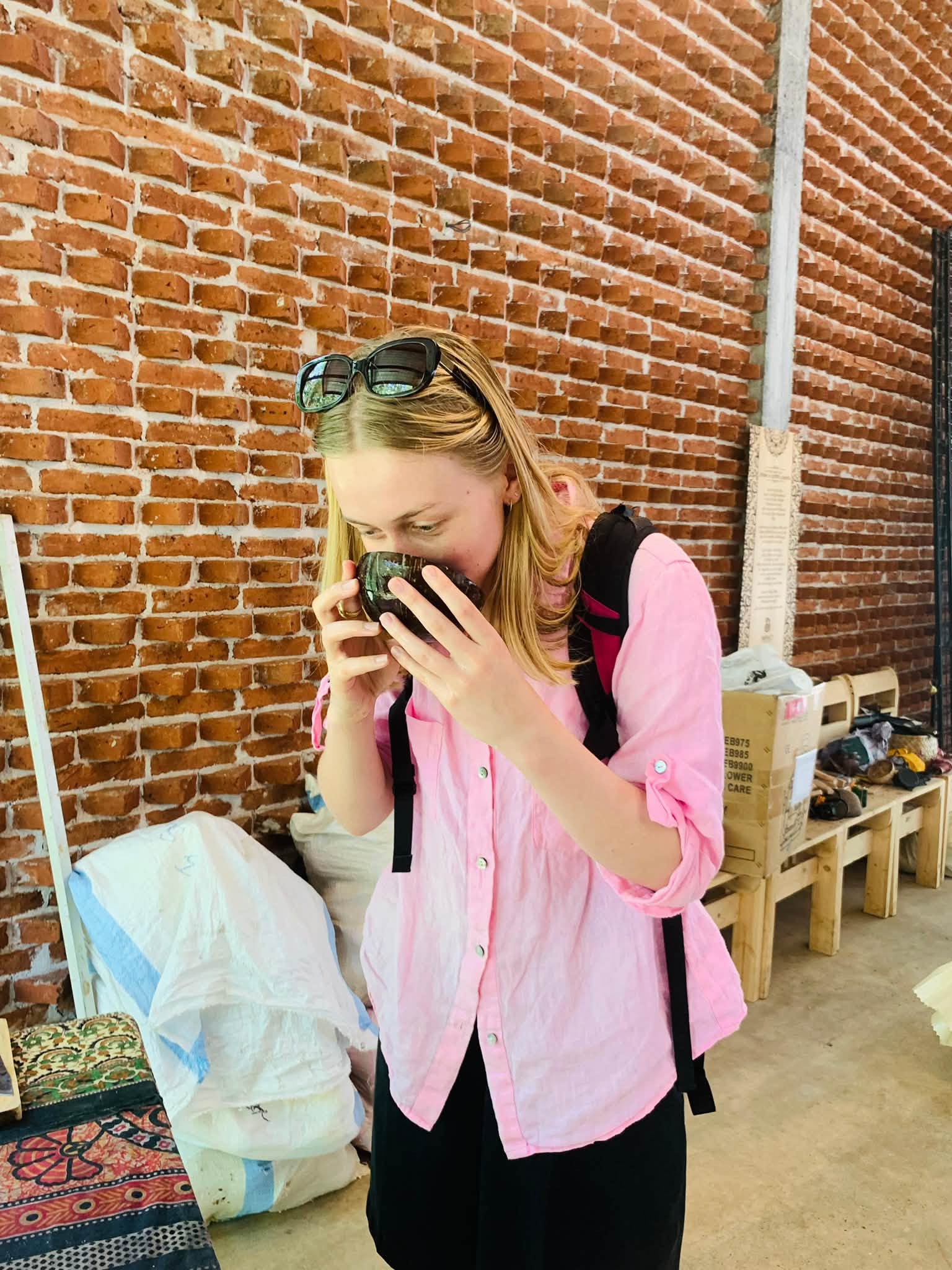 A guest sipping herbal tea from a handcrafted coconut shell cup